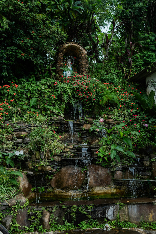 A waterfall in a garden with lots of flowers