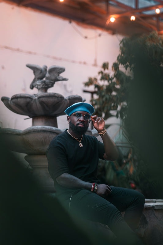 Stylish man sits by a fountain and poses.