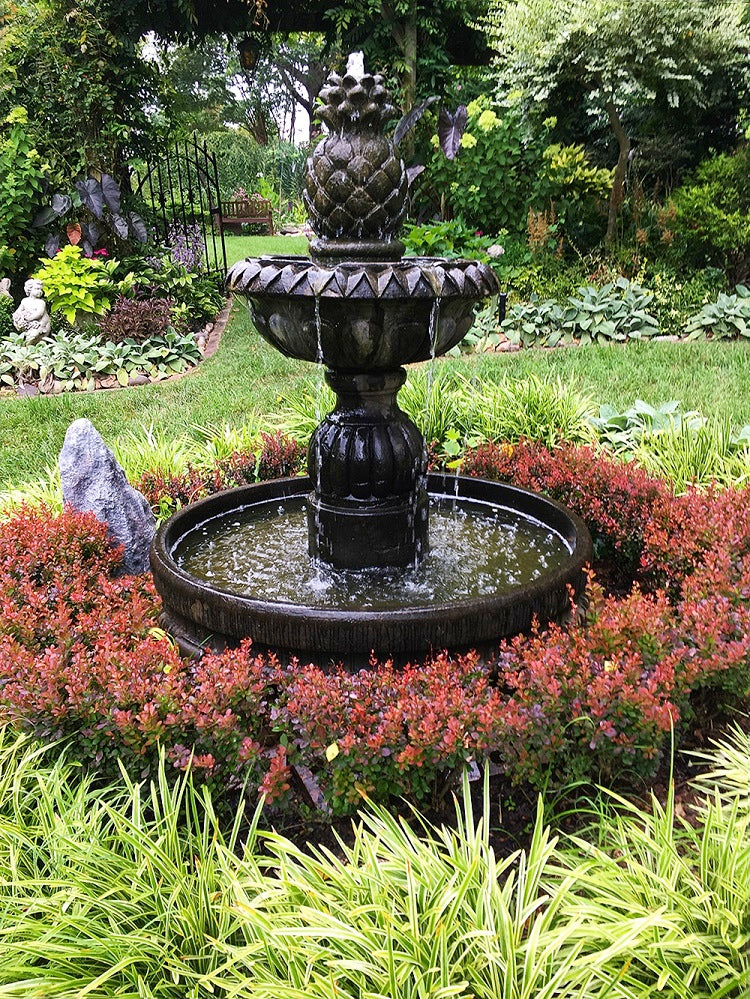 Outdoor fountain with pineapple design in round pool