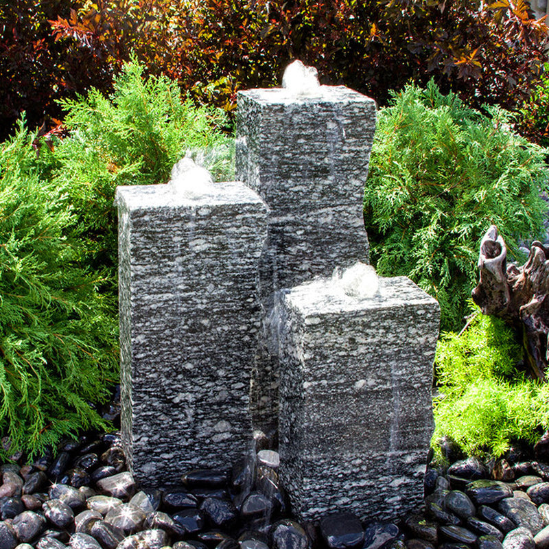 Image of a rough speckled granite triple stone fountain.