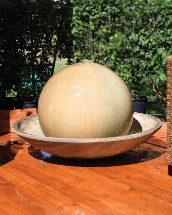Outdoor water fountain featuring a ball and wok design