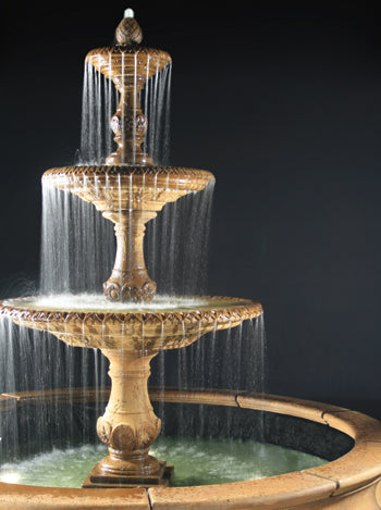 Outdoor water fountain with three tiers and a large basin.