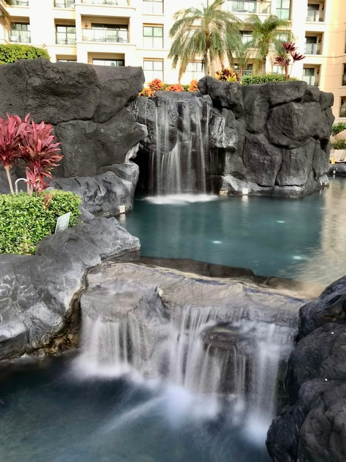 a pool with a waterfall in the middle of it