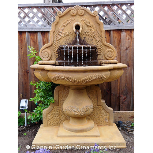 Image of an outdoor wall fountain featuring an olive grove design