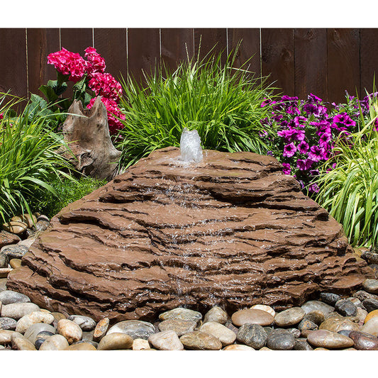 Outdoor water feature with cascading water over natural stone.
