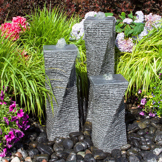 Outdoor water feature with three chiseled twists made from granite stone