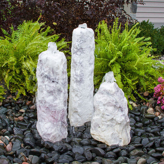Image of a three tiered lilac colored chiseled stone water fountain.