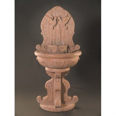 Outdoor wall fountain featuring a dove design